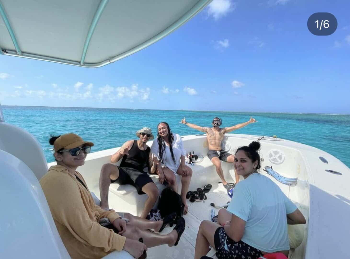 Colorful group of tourists enjoying a boat tour in Belize’s turquoise waters, showcasing Belize Reef Charters' excellent service for snorkeling and sightseeing adventures.