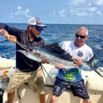 Holding a sailfish caught in Belize on a fishing tour