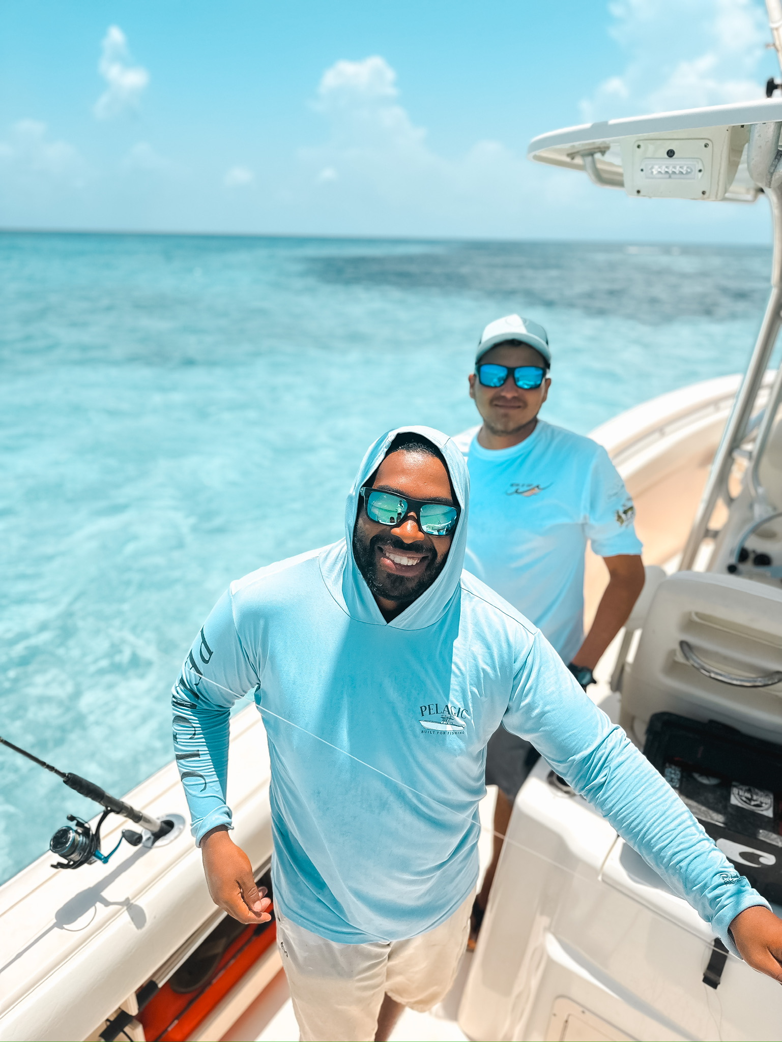 Two experienced fishing guides from Belize Reef Charters showcasing their expertise against the scenic backdrop of Belize's waters.