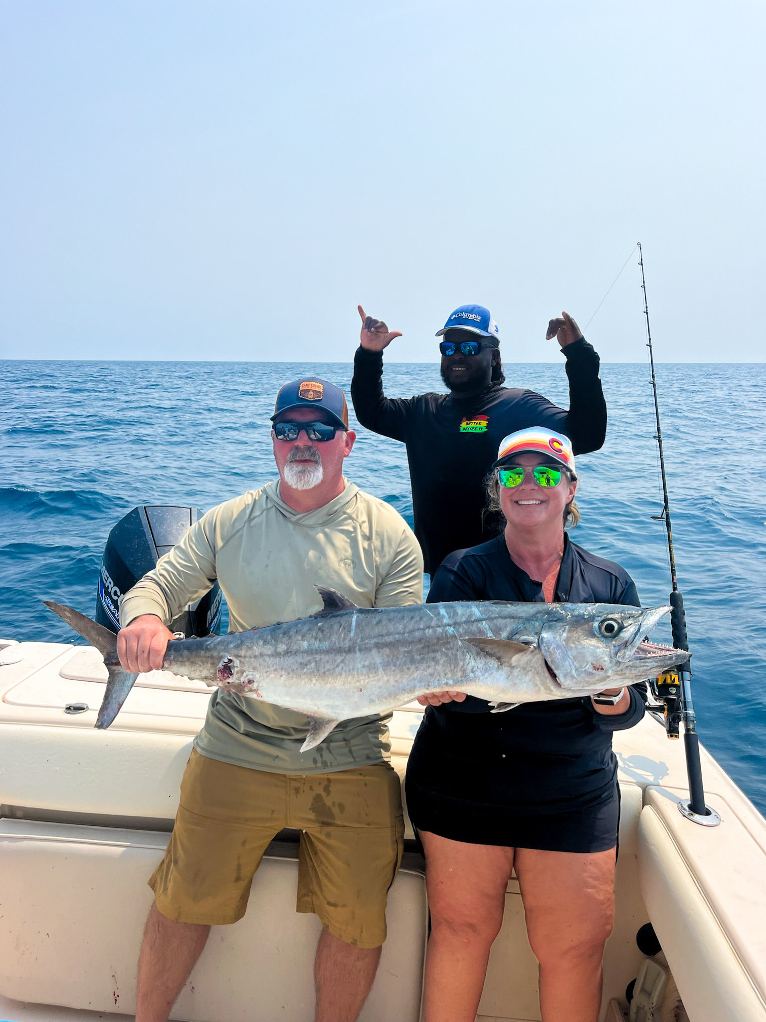 Guests holding their kingfish on a reef fishing trip in Belize.