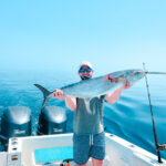 A guest holding a kingfish on a fishing charter in belize.