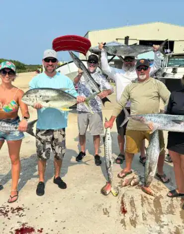 Vibrant group of anglers displaying large catches of fish on Belize Reef Charters, showcasing an exciting day of deep-sea fishing with Belize Reef Charters in Belize.