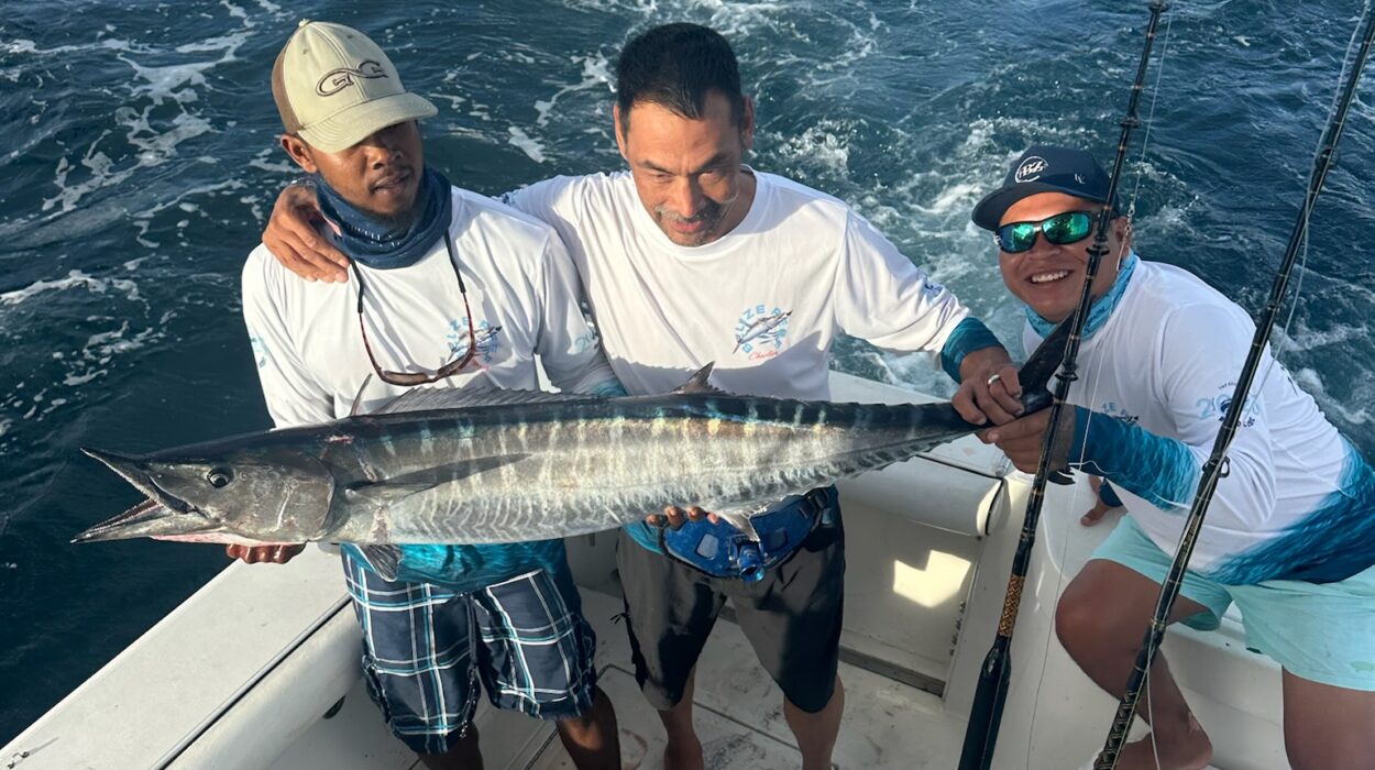 Guests holding a freshly caught wahoo on a deep sea fishing charter in Belize